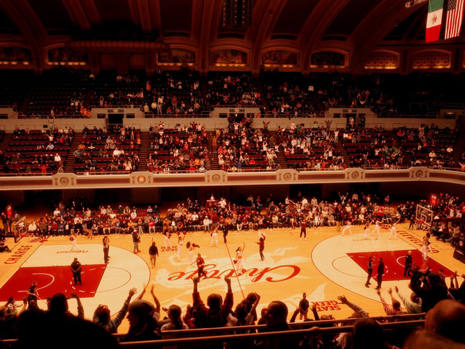 Packed basketball arena with full court lit up
