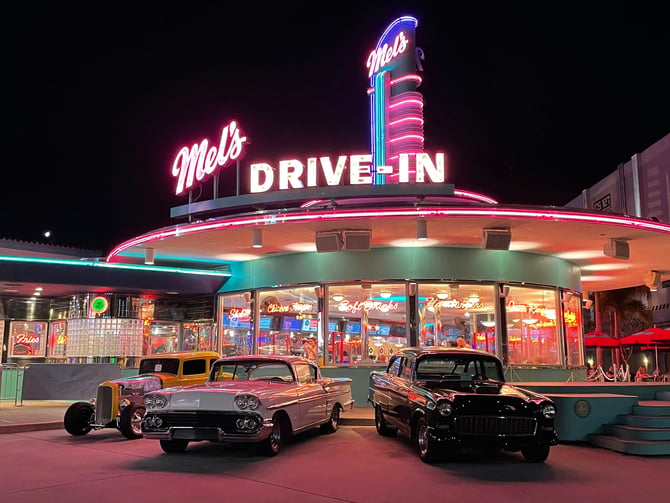 Mel's Drive-In neon sign with classic cars at night