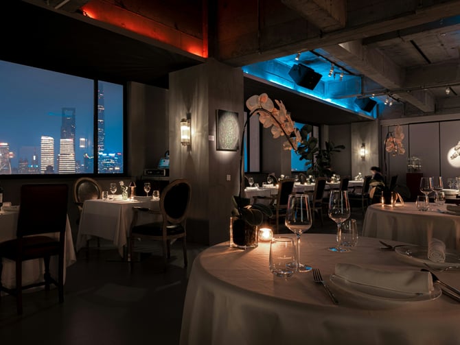 Elegant candlelit restaurant with city skyline view at night