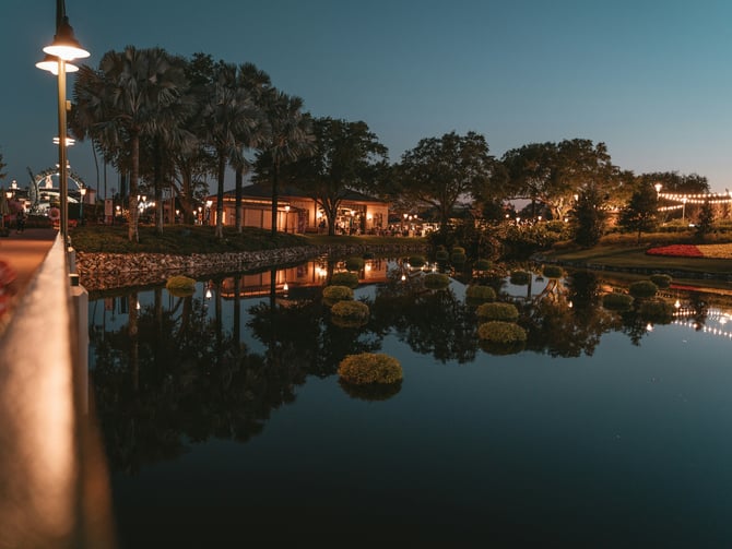 Lakeside resort promenade at dusk with warm reflections