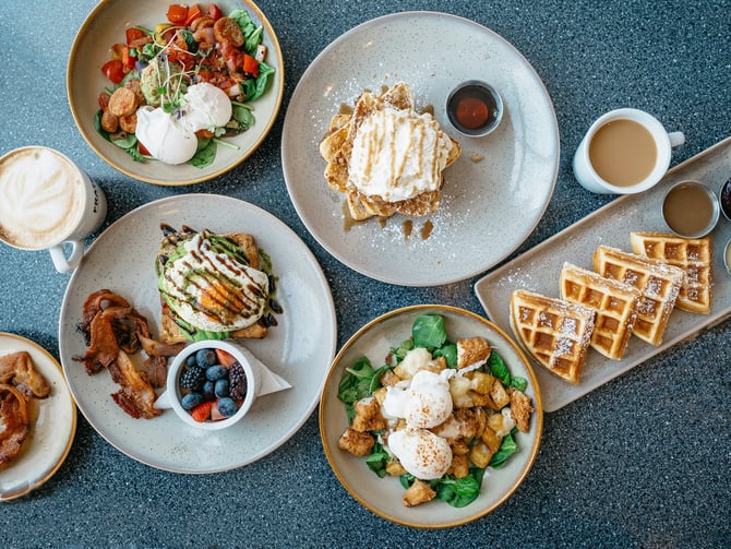 Brunch spread with waffles, eggs, berries and coffee on a table