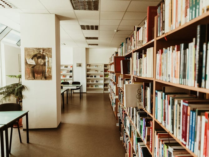 Long aisle of warm wooden bookshelves in a public library
