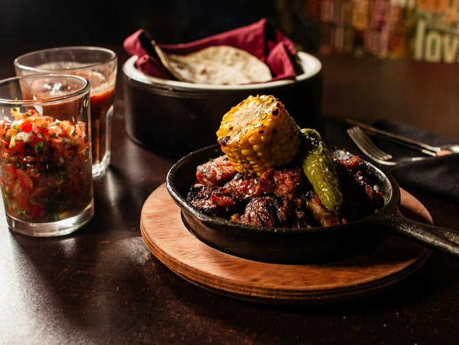 Hearty Mexican barbecue dish with corn, peppers and salsa