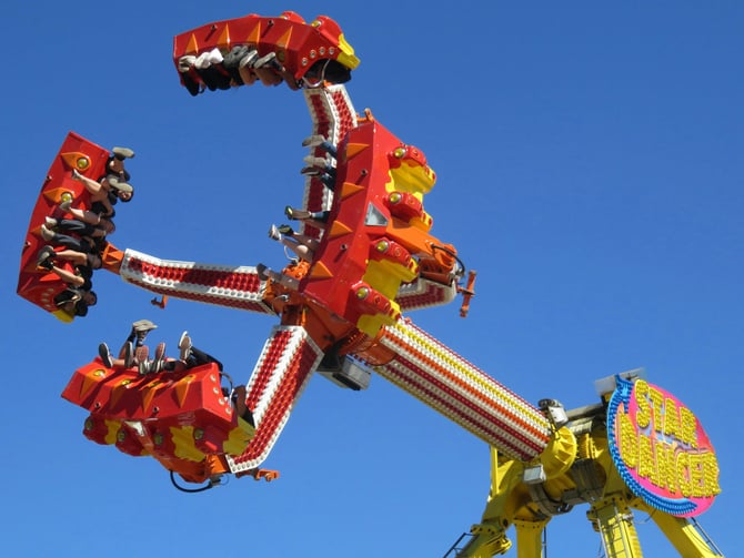 Colorful spinning carnival ride against a bright blue sky