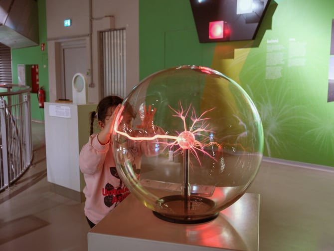 Child touching a plasma ball in a science exhibit