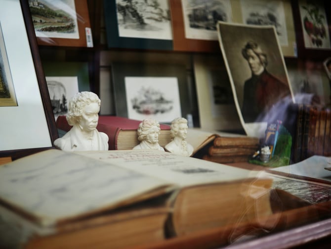 Open books, busts and framed portraits on a vintage desk